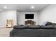 Cozy basement living room with a large dark couch, entertainment center, and a television at 10101 E 112Th Way, Commerce City, CO 80640