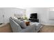 Comfortable living room featuring a sectional sofa, hardwood floors, and a large window at 10101 E 112Th Way, Commerce City, CO 80640