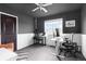 This home office offers a large window, dark colored walls, white trim, ceiling fan and carpet at 10101 E 112Th Way, Commerce City, CO 80640
