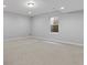 Large, empty basement with carpet flooring, a small window and recessed lighting throughout at 5755 Boston St, Denver, CO 80238