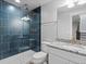 Modern bathroom featuring a glass-enclosed shower with blue tile and a vanity with granite countertop at 5755 Boston St, Denver, CO 80238