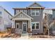 Charming gray two-story home with inviting front porch and manicured landscaping at 5755 Boston St, Denver, CO 80238