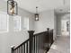 Upstairs hallway with modern lighting fixtures, dark wood banister and carpeted floor at 5755 Boston St, Denver, CO 80238