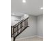 Carpeted staircase with a wooden railing leads to the upper level, illuminated by recessed lighting at 5755 Boston St, Denver, CO 80238