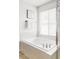 Bright bathroom featuring a soaking tub with chrome fixtures and a large window at 6385 S Nelson Way, Littleton, CO 80127