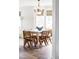 Bright dining area featuring a rustic table with seating for six, complemented by a modern chandelier and natural light at 6385 S Nelson Way, Littleton, CO 80127