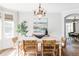 Elegant dining room with a stylish chandelier, a modern table setting, and bright light from adjacent window at 6385 S Nelson Way, Littleton, CO 80127