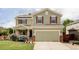 Charming two-story home featuring red shutters, green siding, a two-car garage, and a beautifully landscaped front yard at 6385 S Nelson Way, Littleton, CO 80127