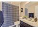 Well-lit bathroom features a granite countertop, new fixtures, stylish shower curtain and ample storage at 3795 Depew St # D, Wheat Ridge, CO 80212