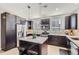 Modern kitchen features dark cabinets, stainless steel appliances, pendant lights and a large center island with bar seating at 3795 Depew St # D, Wheat Ridge, CO 80212