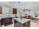 Modern kitchen with a central island and stainless steel appliances opening to the living room at 3795 Depew St # D, Wheat Ridge, CO 80212