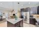 Open kitchen with stainless steel appliances, granite counters, and dark cabinets flowing to the living area at 3795 Depew St # D, Wheat Ridge, CO 80212