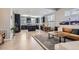 Open floor plan with modern kitchen, wood floors, a dark kitchen island, and stylish living room furniture at 3795 Depew St # D, Wheat Ridge, CO 80212