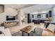 Modern living room featuring an open floor plan with wood floors, a dark kitchen, and stylish furniture at 3795 Depew St # D, Wheat Ridge, CO 80212