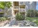Charming condo exterior featuring stairs to unit entrance, maintained landscaping, and rock features at 4068 S Atchison Way # 101, Aurora, CO 80014