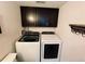 Laundry room with dark cabinets, laundry machines and a white wall at 14396 E Temple Pl # A, Aurora, CO 80015