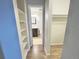 Hallway leading to bathroom with built-in shelving and ample storage at 2325 S Linden Ct # 211, Denver, CO 80222