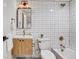 Stylish bathroom with black and white tile and wood vanity at 5576 E Lehigh Ave, Denver, CO 80237