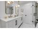 Modern bathroom with double vanity, marble tile, and walk-in shower at 5576 E Lehigh Ave, Denver, CO 80237