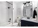 Stylish bathroom with sleek bathtub and shower, modern fixtures, and navy blue vanity at 5068 E Crestone Ave, Castle Rock, CO 80104