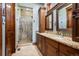 Updated bathroom featuring double sinks, granite counters, custom cabinets and a walk-in shower at 2480 Castle Butte Dr, Castle Rock, CO 80109