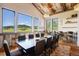 Open dining room with a long table, seating for twelve, and large windows showcasing scenic views at 2480 Castle Butte Dr, Castle Rock, CO 80109