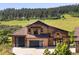 A two-story home boasts a three car garage, stone accents and modern garage doors at 2480 Castle Butte Dr, Castle Rock, CO 80109
