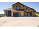 A two-story home boasts a three car garage, stone accents and modern garage doors at 2480 Castle Butte Dr, Castle Rock, CO 80109