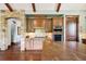 Bright kitchen with wood cabinetry, stone backsplash, and a large center island at 2480 Castle Butte Dr, Castle Rock, CO 80109
