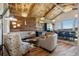 Bright living area featuring a rustic ceiling, modern lighting, kitchenette, and a curved sofa at 2480 Castle Butte Dr, Castle Rock, CO 80109