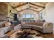 Comfortable living area with rustic ceiling, stylish chandeliers, kitchenette, and a large curved sofa at 2480 Castle Butte Dr, Castle Rock, CO 80109