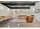 Cozy living area with concrete floors, brick accent wall, and comfortable seating with views from the window at 2480 Castle Butte Dr, Castle Rock, CO 80109