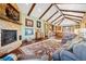 Spacious living room featuring a stone fireplace, vaulted ceilings, and an elegant area rug at 2480 Castle Butte Dr, Castle Rock, CO 80109