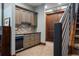 Hallway wet bar with granite countertop, mosaic backsplash, wine glass rack, and beverage refrigerator at 2480 Castle Butte Dr, Castle Rock, CO 80109