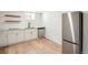 Basement kitchen with stainless steel appliances, bright cabinets, and hardwood flooring at 3780 Benton St, Wheat Ridge, CO 80212