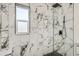 Modern bathroom shower boasting a rainfall shower head and marble tile at 3780 Benton St, Wheat Ridge, CO 80212