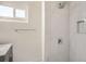 Bathroom featuring updated fixtures, white tiled shower with a built-in niche and a small window at 3780 Benton St, Wheat Ridge, CO 80212