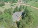 Aerial view of a house surrounded by mature trees and green grass in a rural setting at 9212 Tanglewood Rd, Franktown, CO 80116