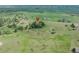 Aerial view of a house in a rural setting with green grass and mature trees at 9212 Tanglewood Rd, Franktown, CO 80116