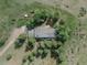 Aerial view of a house surrounded by mature trees and green grass at 9212 Tanglewood Rd, Franktown, CO 80116