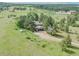 Expansive property featuring lush greenery, mature trees, and a charming home with a spacious driveway and attached garage at 9212 Tanglewood Rd, Franktown, CO 80116