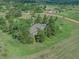 Aerial view of a house surrounded by mature trees and green grass in a rural setting at 9212 Tanglewood Rd, Franktown, CO 80116