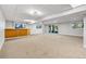 Large finished basement area with a bar, carpeting, drop ceiling, and natural light from the windows and sliding door at 9212 Tanglewood Rd, Franktown, CO 80116