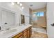 Bright bathroom featuring a double sink vanity, white tile, and glass enclosed shower with a built-in seat at 9212 Tanglewood Rd, Franktown, CO 80116