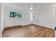 Bedroom with light hardwood floors and large picture window views of mature trees at 9212 Tanglewood Rd, Franktown, CO 80116
