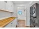 Well-organized laundry room with white cabinets, wood countertop, and modern washer and dryer at 9212 Tanglewood Rd, Franktown, CO 80116
