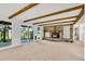 Inviting living room featuring wood beam ceilings, a cozy stone fireplace, large windows, and plush carpeting at 9212 Tanglewood Rd, Franktown, CO 80116