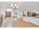 Spacious living room with hardwood floors, chandelier and an open layout to kitchen and entry at 9212 Tanglewood Rd, Franktown, CO 80116