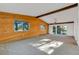 Spacious living room featuring wood-paneled walls, a large window, and a walkout patio at 9212 Tanglewood Rd, Franktown, CO 80116