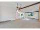 Large living room with beamed ceilings, ample natural light, plush carpeting, and an open layout to the kitchen at 9212 Tanglewood Rd, Franktown, CO 80116